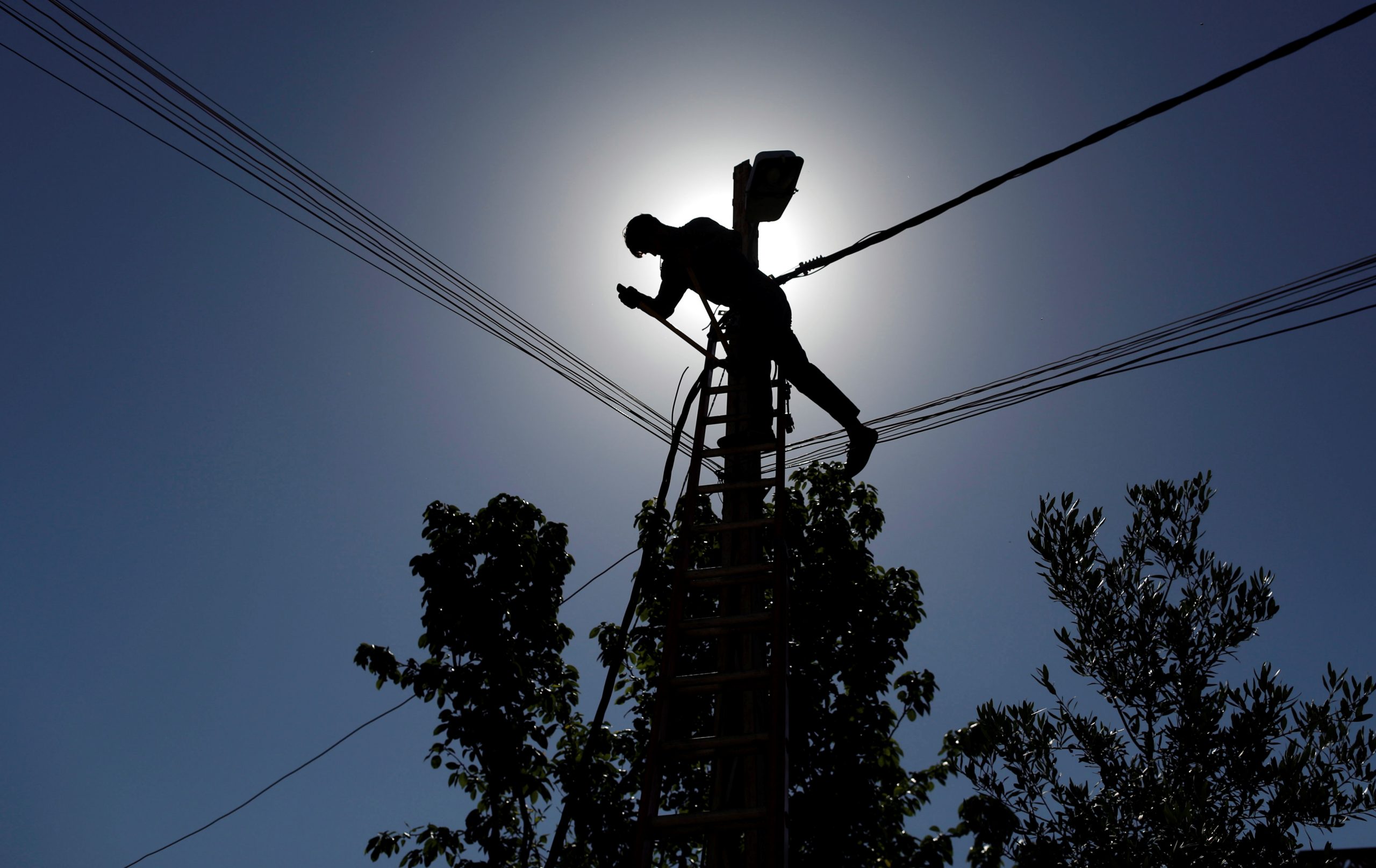 A technician works on an electricity pole damaged during fighting between Iraqi forces and the Islamic State in Iraq and the Levant, in eastern Mosul, Iraq April 26, 2017. (REUTERS/Danish Siddiqui)