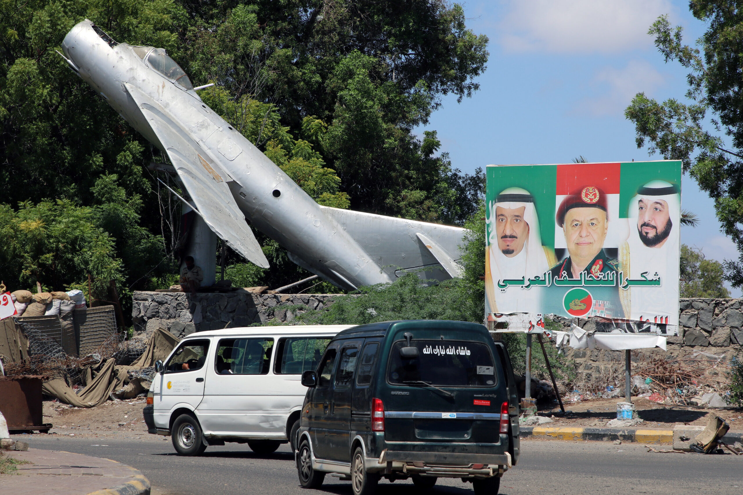 Vans drive past a billboard with posters of Saudi King Salman bin Abdulaziz, left, Yemeni President Abd Rabbu Mansour Hadi, center, and UAE President Khalifa bin Zayed al-Nahyan, in Aden, Yemen, October 17 , 2019. (REUTERS/Fawaz Salman)