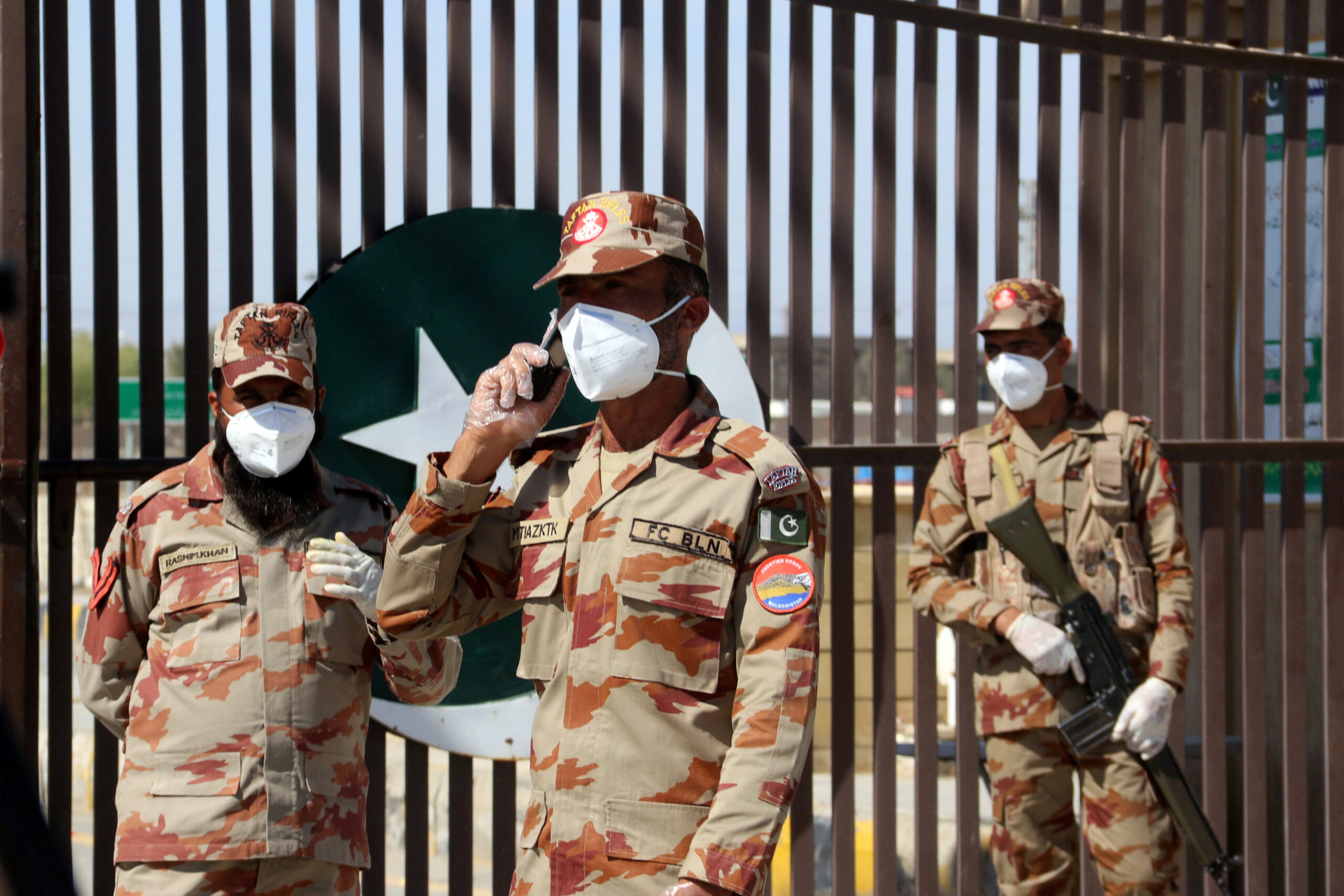 Paramilitary stand in front of a closed gate of Pakistan's border post, after Pakistan sealed its border with Iran as a preventive measure following the coronavirus outbreak, Taftan, Pakistan, Feb. 25, 2020. (REUTERS/Naseer Ahmed)