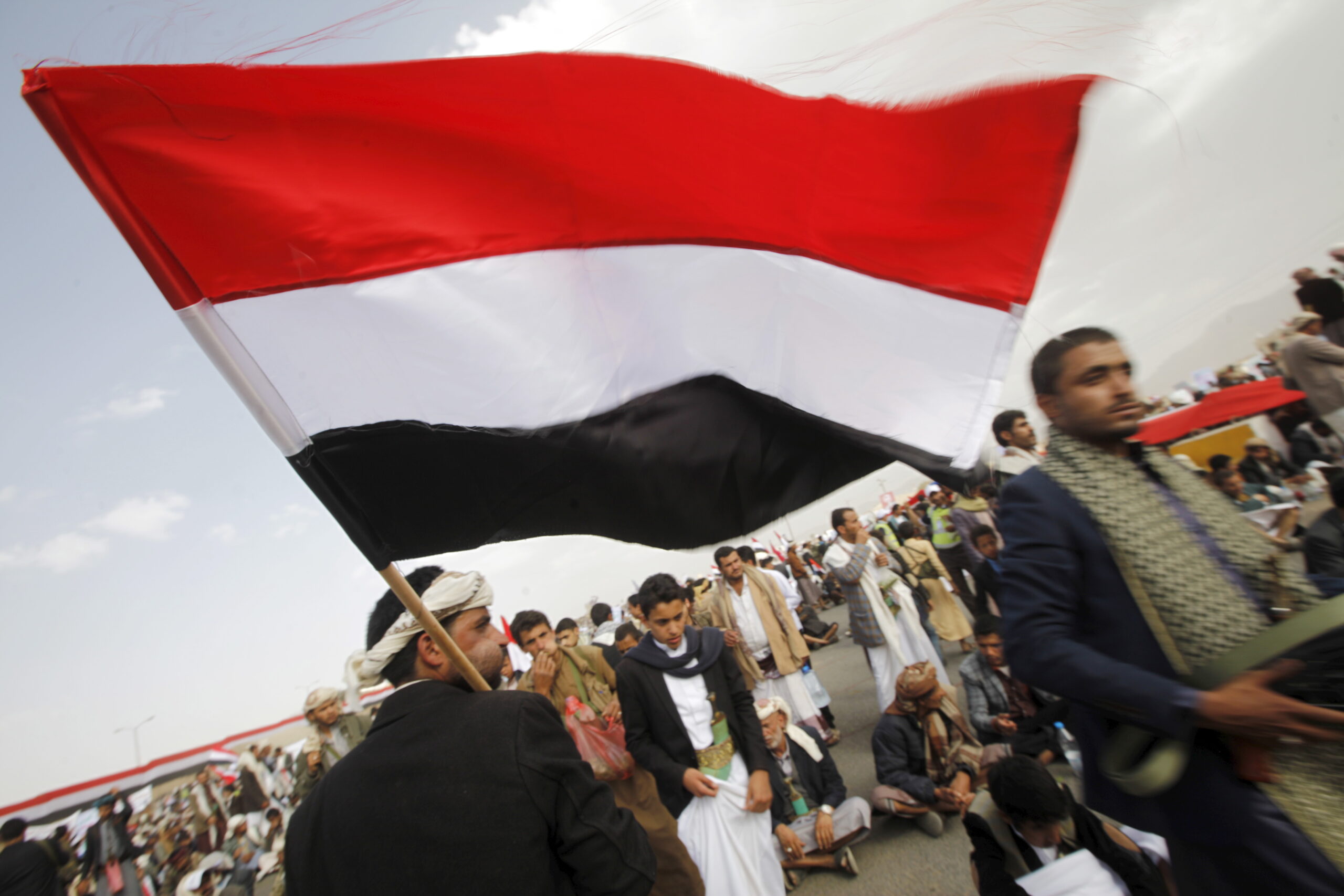 A Houthi follower carries Yemen's national flag at a rally marking one year of Saudi-led airstrikes, in Yemen's capital Sanaa, March 26, 2016. (REUTERS/Mohamed al-Sayaghi)