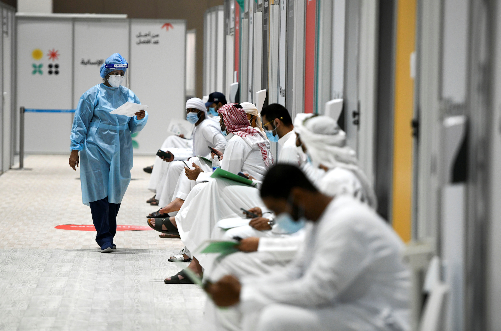 People sit as they wait their turn for vaccine trials at Abu Dhabi National Exhibition Centre, Abu Dhabi, United Arab Emirates, October 6, 2020. (REUTERS/Khushnum Bhandari)