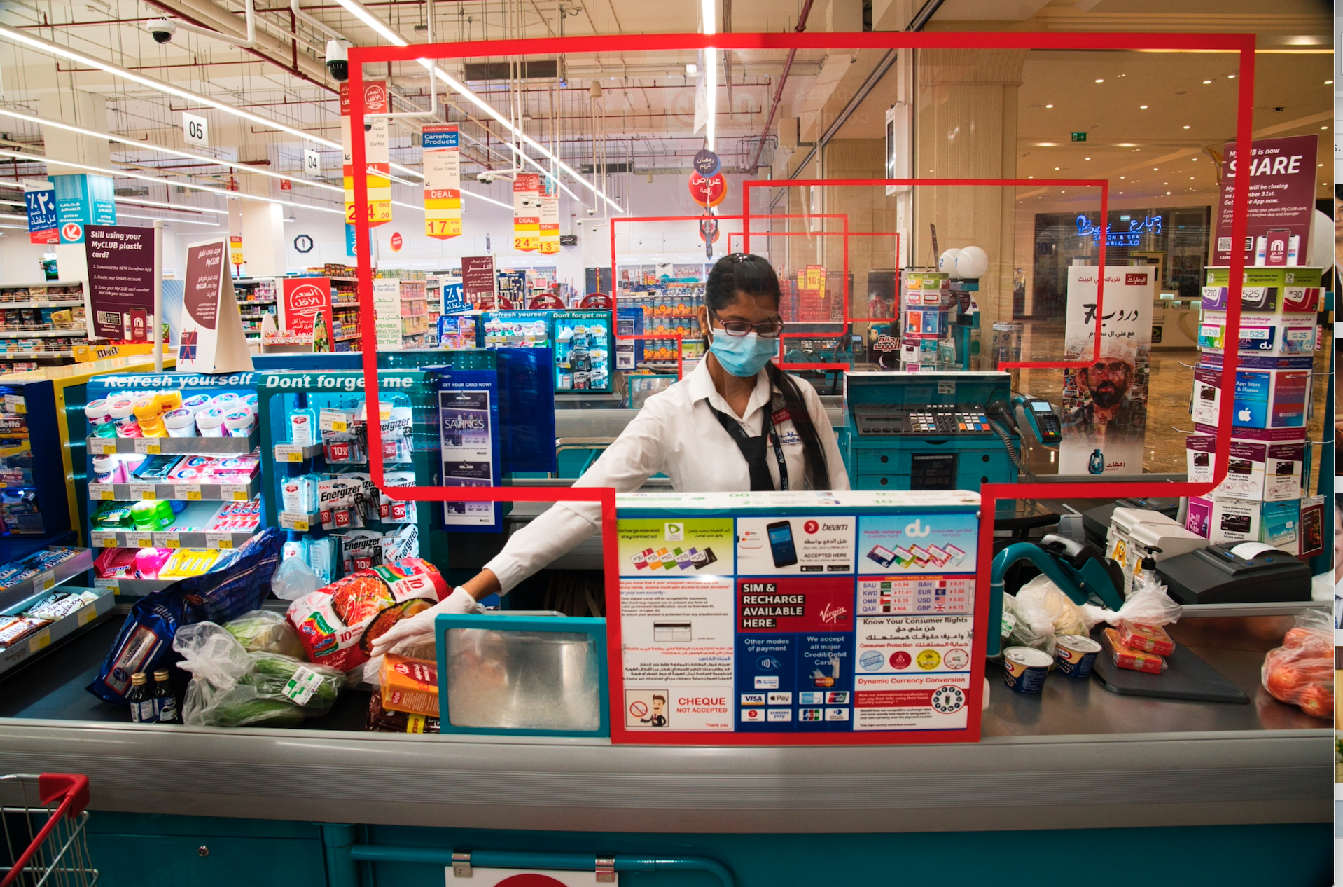 Cashier Valancy Fernandes of India, wearing a surgical mask and gloves to help prevent the spread of coronavirus, works at a Carrefour supermarket in Dubai, United Arab Emirates, April 19. (AP Photo/Jon Gambrell)