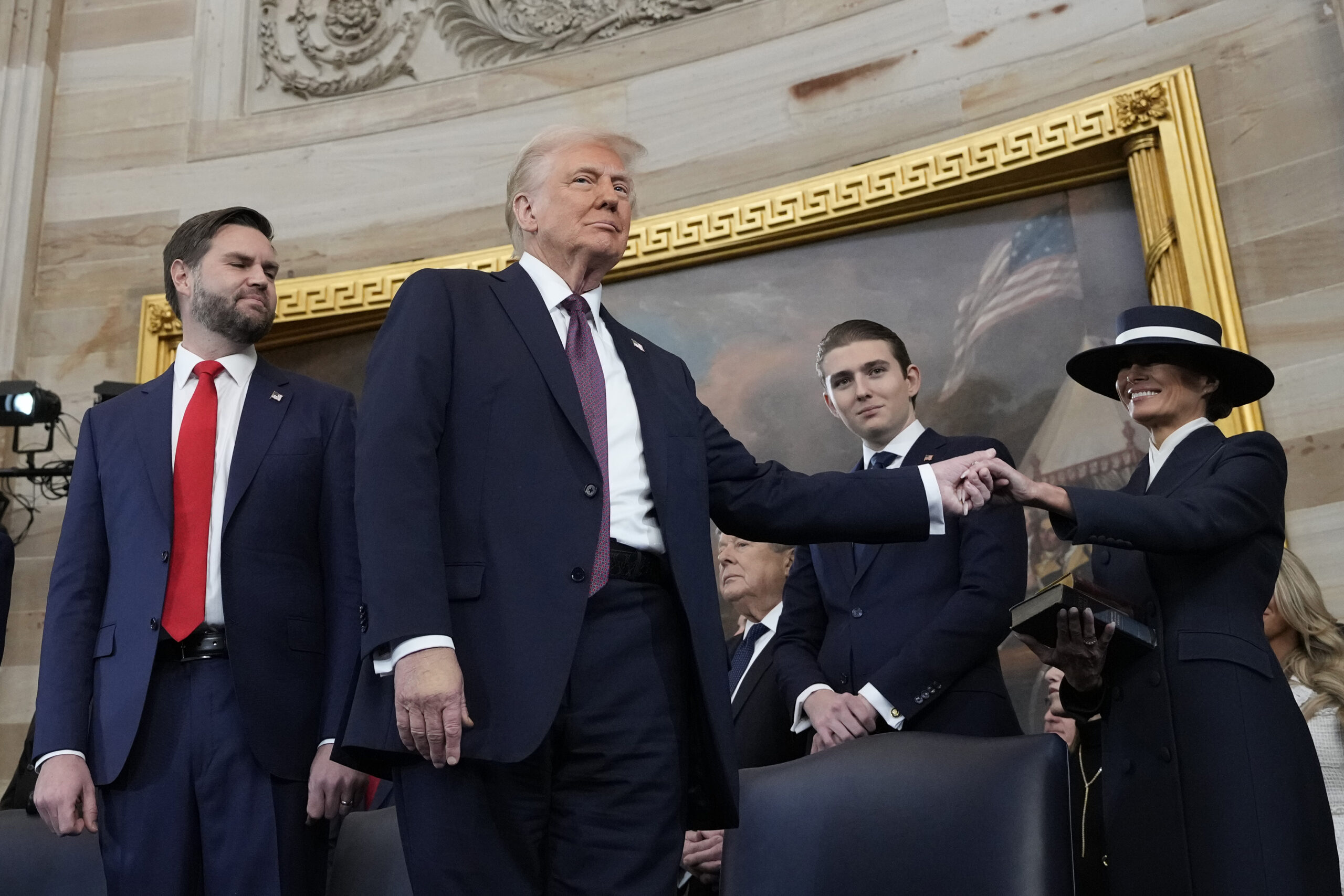 President Donald J. Trump holds the hand of his wife Melania Trump, right, as Vice President JD Vance looks on after taking the oath of office during the 60th Presidential Inauguration in Washington, DC, January 20. (AP Photo/Morry Gash, Pool)