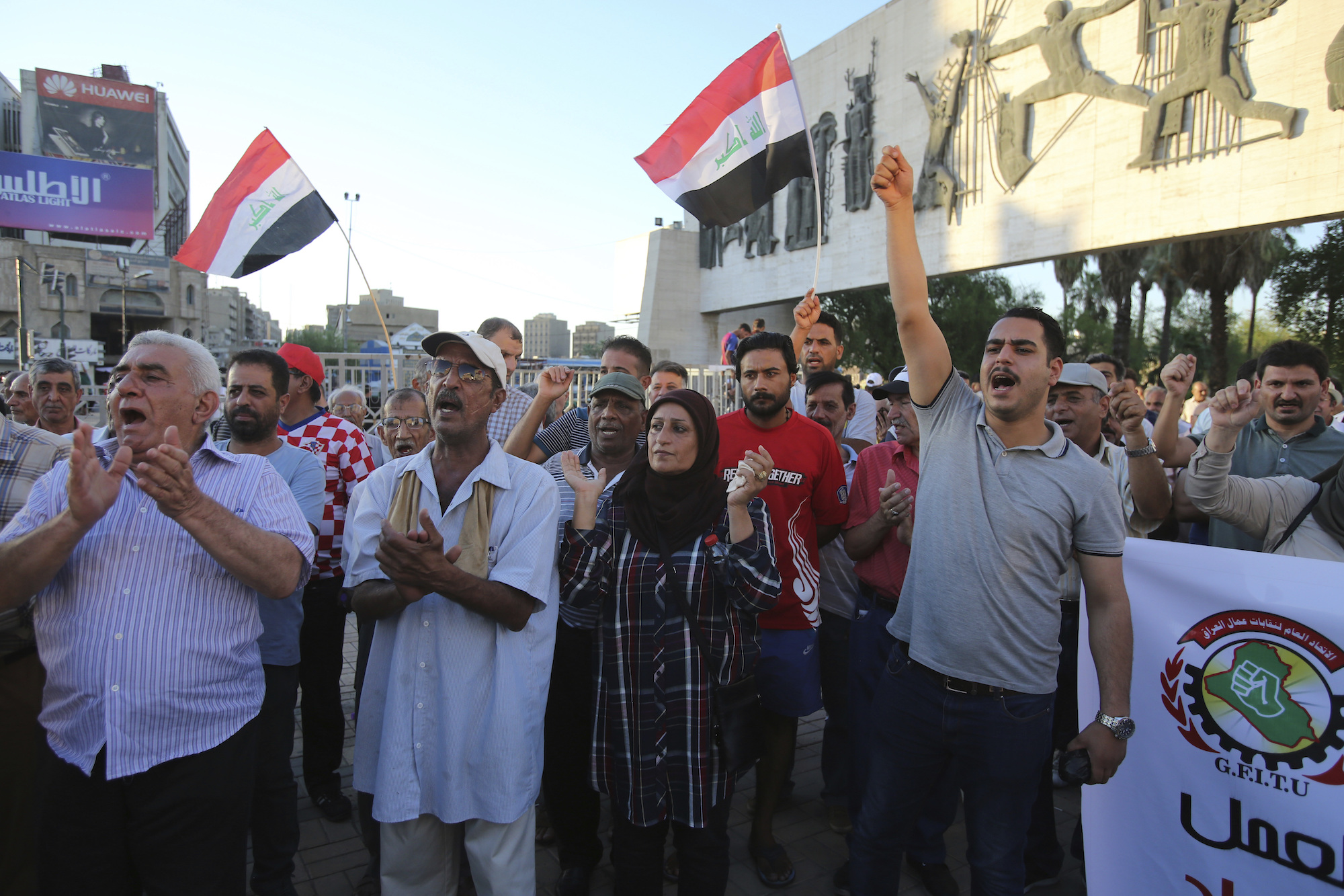Protesters chant slogans demanding services as they wave national flags during a demonstration in Tahrir Square in Baghdad, Iraq, Aug. 10. (AP Photo/Karim Kadim)