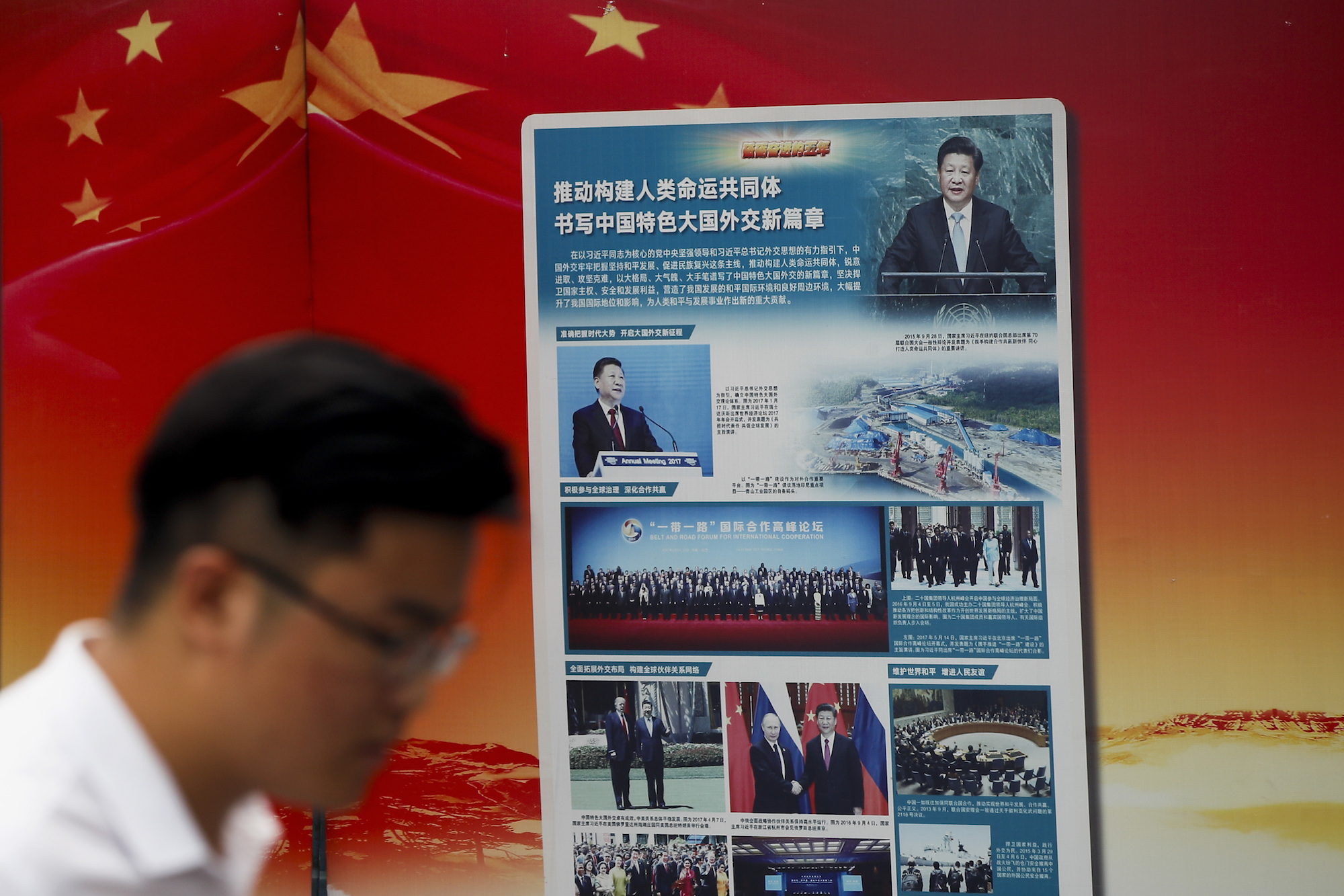 A man walks by a billboard promoting Chinese President Xi Jinping's signature Belt and Road Initiative outside a subway station in Beijing, China, Aug. 28. (AP Photo/Andy Wong)