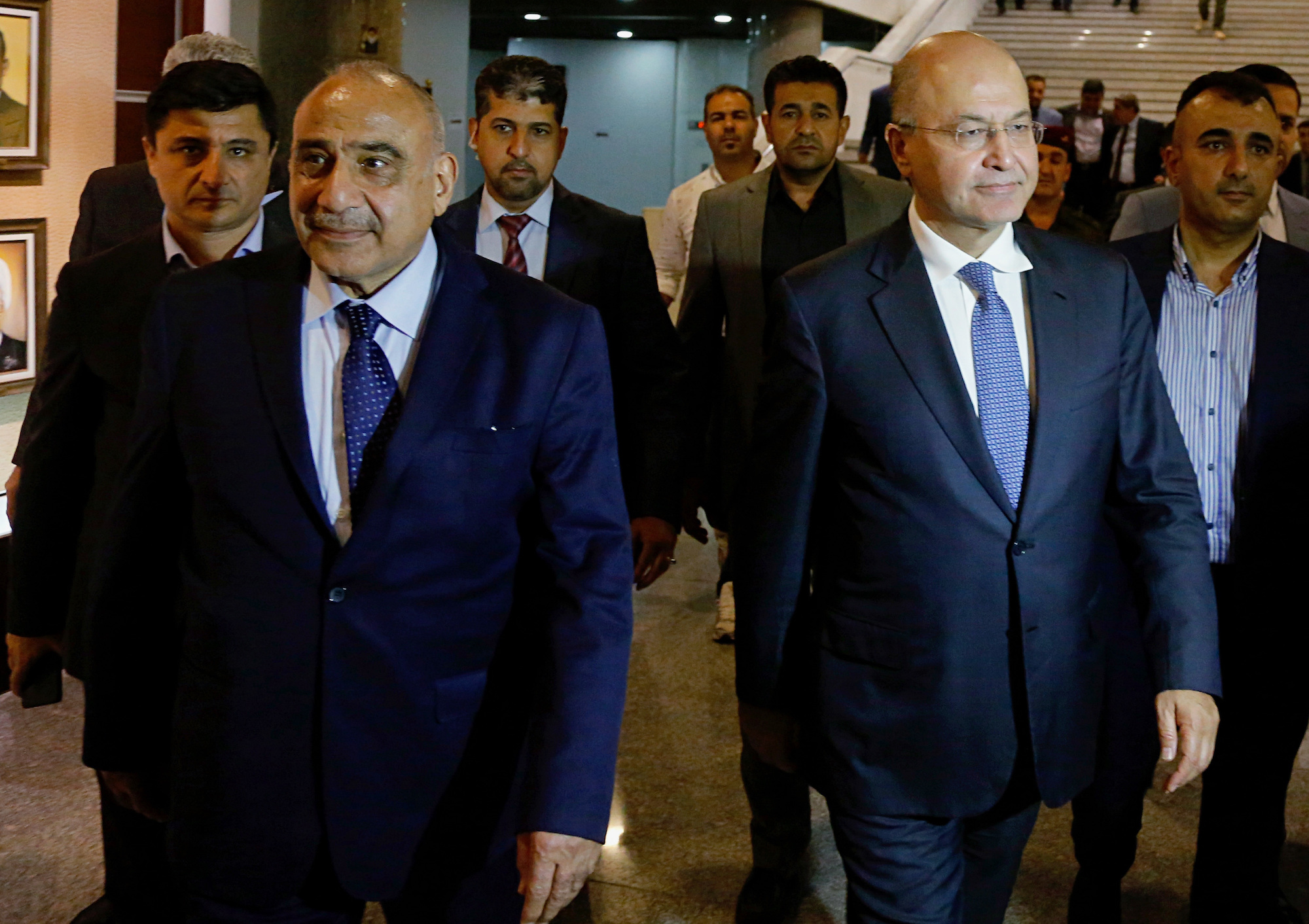 Newly elected Iraqi President Barham Salih, center right, walks with newly elected Iraqi prime minister Adel Abdul Mahdi, center left, in Baghdad, Iraq, Oct. 2. (AP Photo/Karim Kadim)