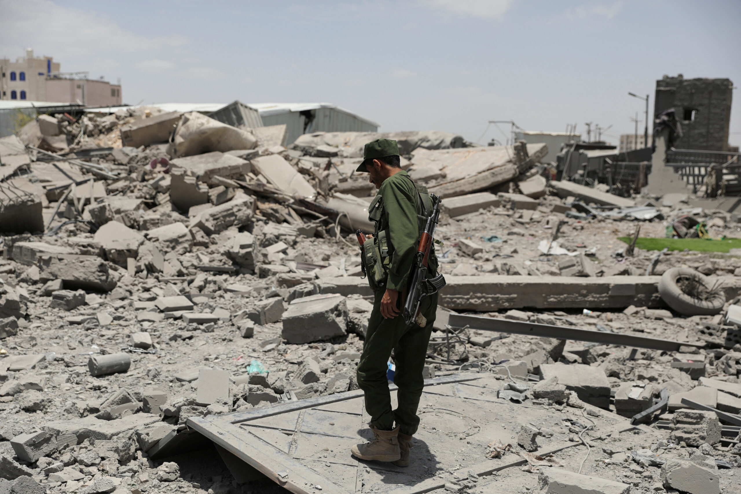 A police trooper stands on the rubble of a building destroyed by U.S. air strikes in Sanaa, Yemen April 27. (REUTERS/Khaled Abdullah)