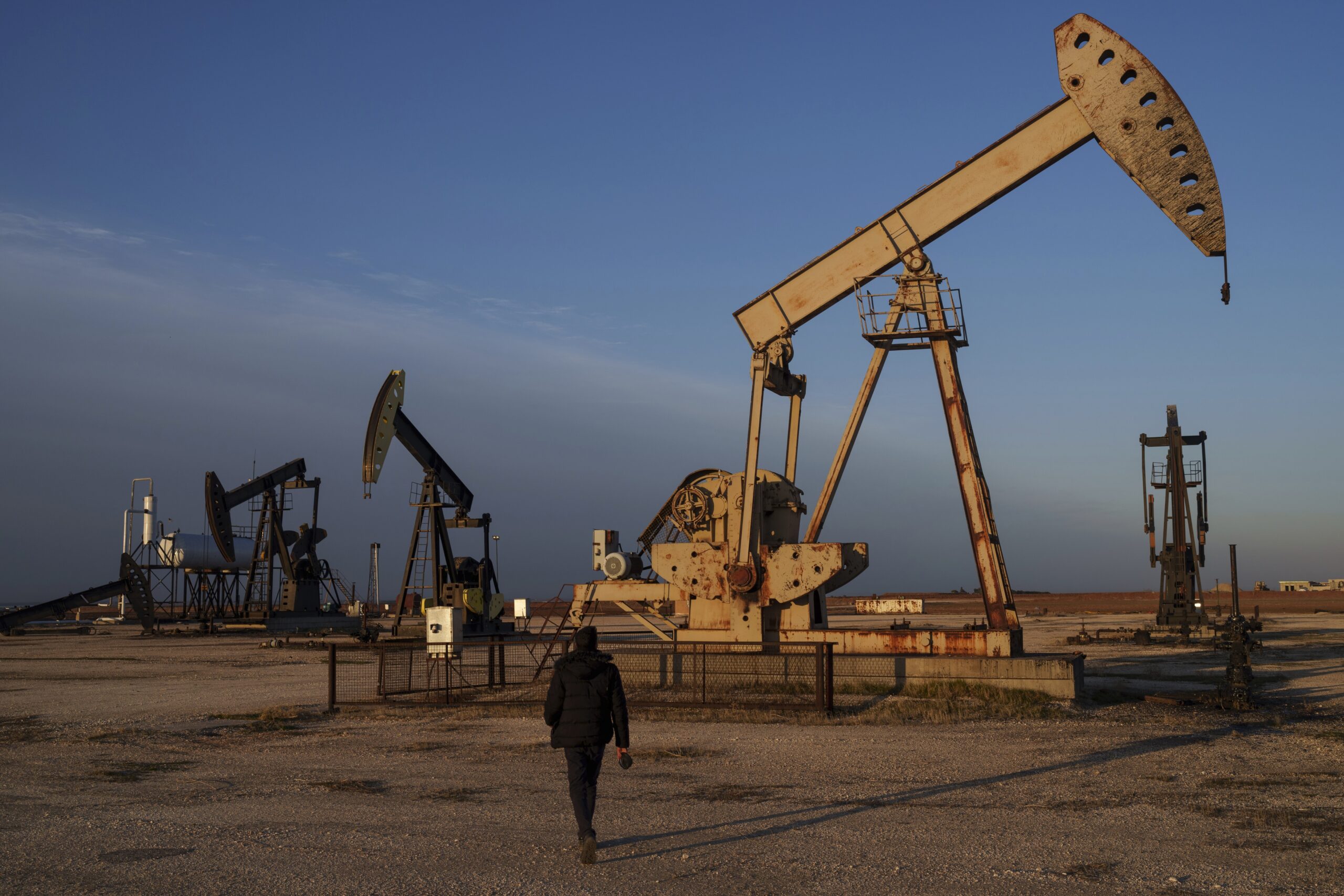 A worker walks past idle pumpjacks at an oil field on the outskirts of Qamishli, Syria, Feb. 3. (AP Photo/Bernat Armangue)