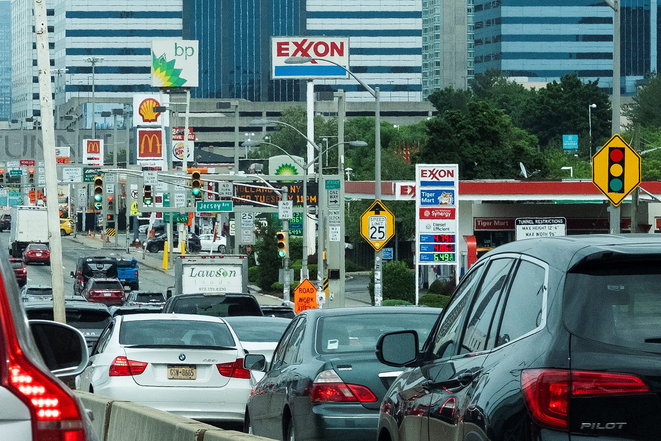 People drive their cars near Exxon and BP gas stations at the exit of the Holland Tunnel during the start of the Memorial Day weekend, under rising gas prices, in Newport, New Jersey, May 27. (REUTERS/Eduardo Munoz)