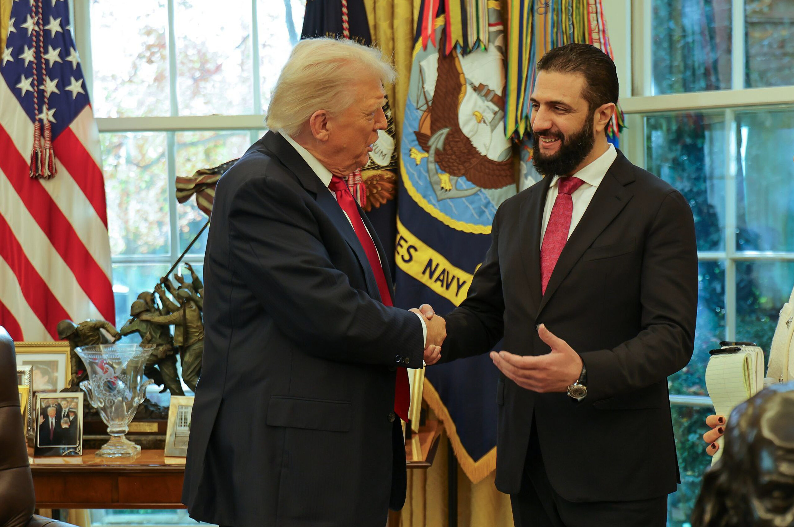 President Donald J. Trump, left, shakes hands with Syrian President Ahmed al-Sharaa, at the White House in Washington, Monday, Nov. 10, 2025. (Syrian Presidency press office via AP)