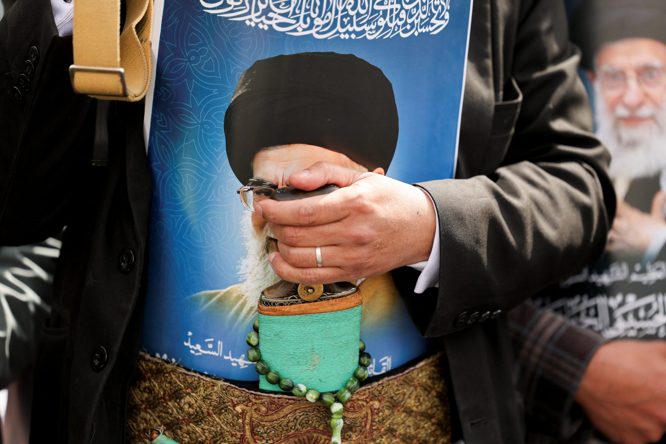 A man with a poster featuring a picture of late Iranian Supreme Leader Ayatollah Ali Khamenei tucked in his garment joins a demonstration with Houthi supporters in Sanaa, Yemen, March 6. (REUTERS/Khaled Abdullah)
