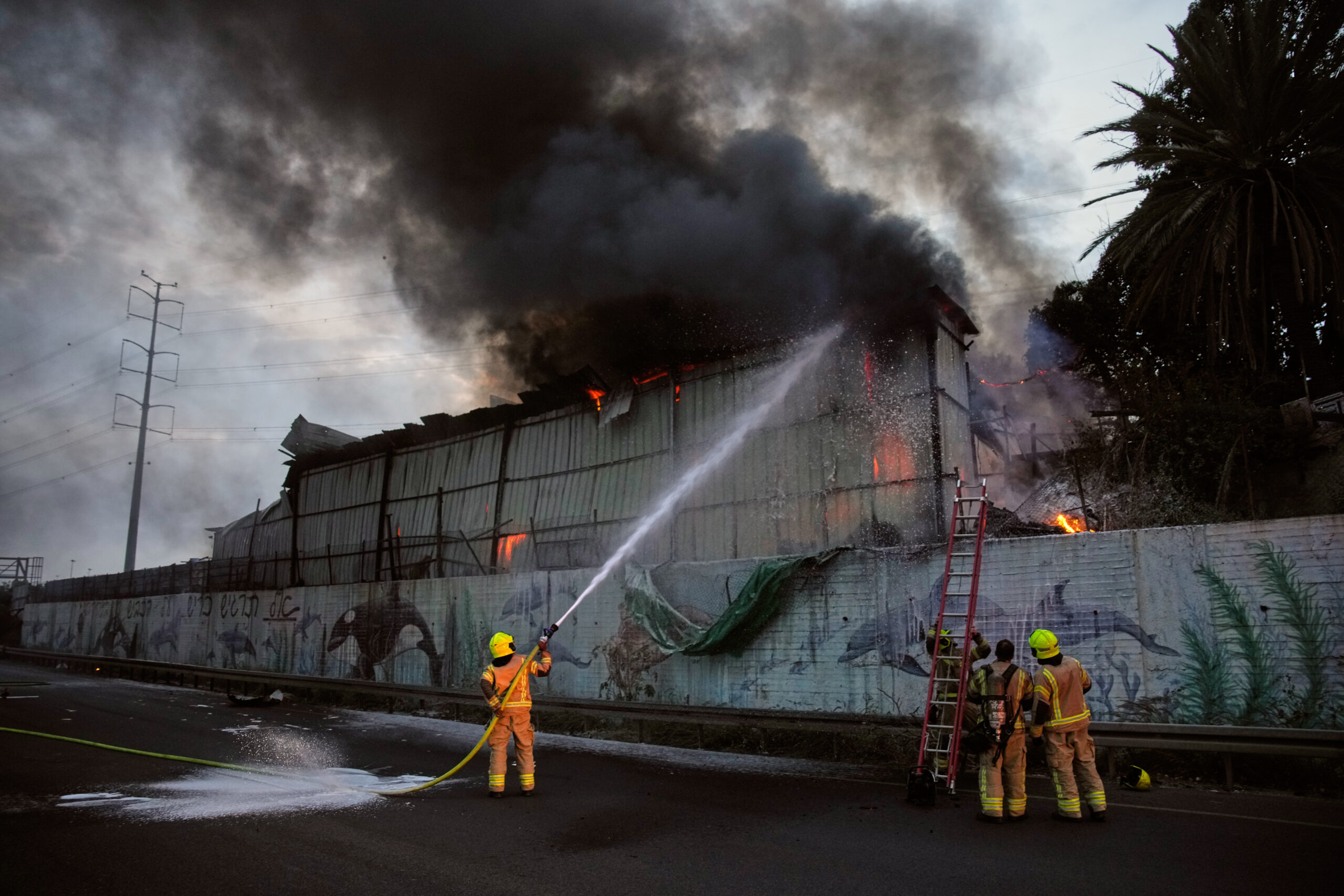 Firefighters try to extinguish flames at the site of a direct hit by an Iranian missile strike in Holon, central Israel, March 13,. (AP Photo/Ohad Zwigenberg)