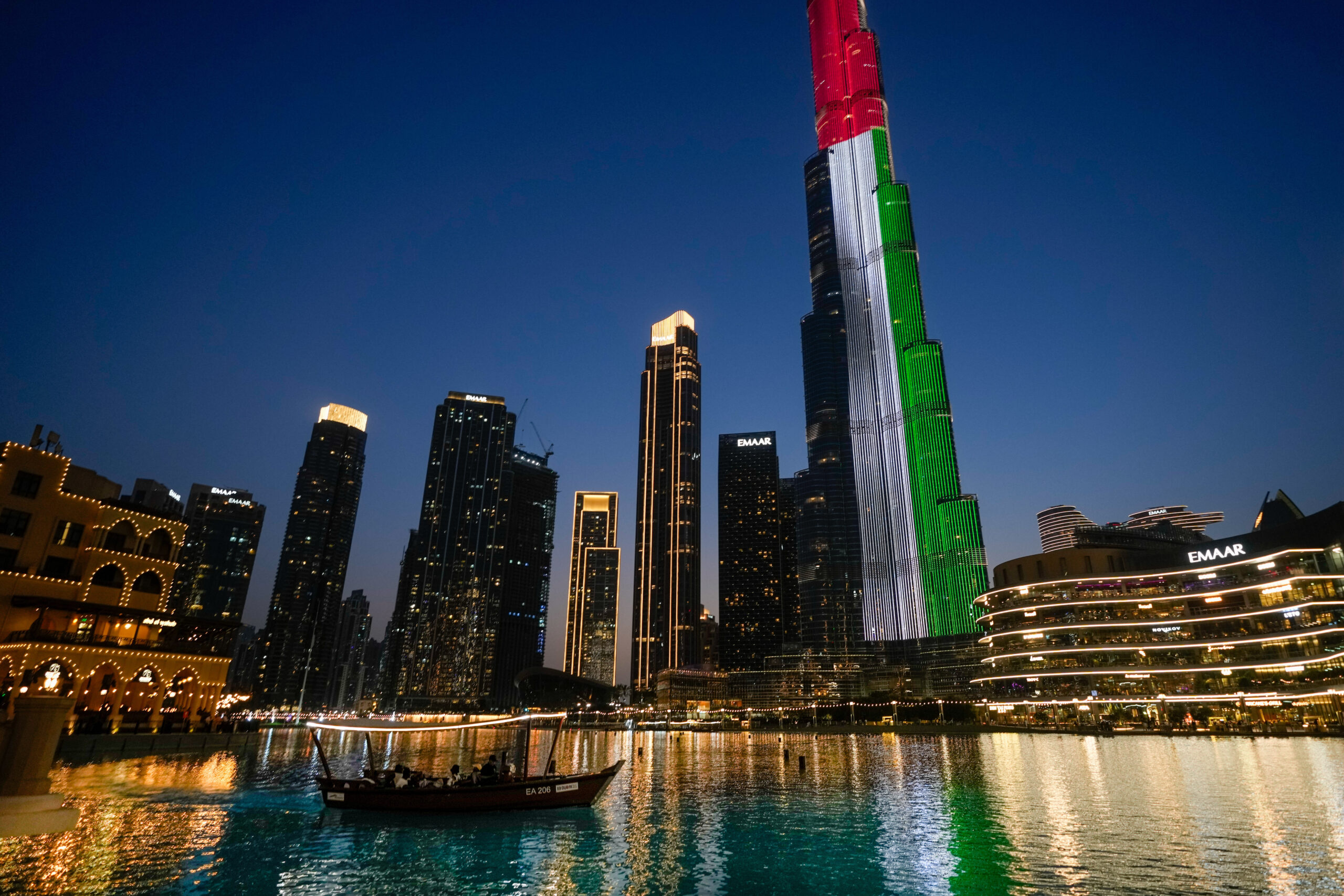 A boat takes tourists to watch a Dubai fountain show as Burj Khalifa, the world's tallest building, is illuminated with the United Arab Emirates national flag colors in Dubai, UAE, May 6. (AP Photo/Altaf Qadri)