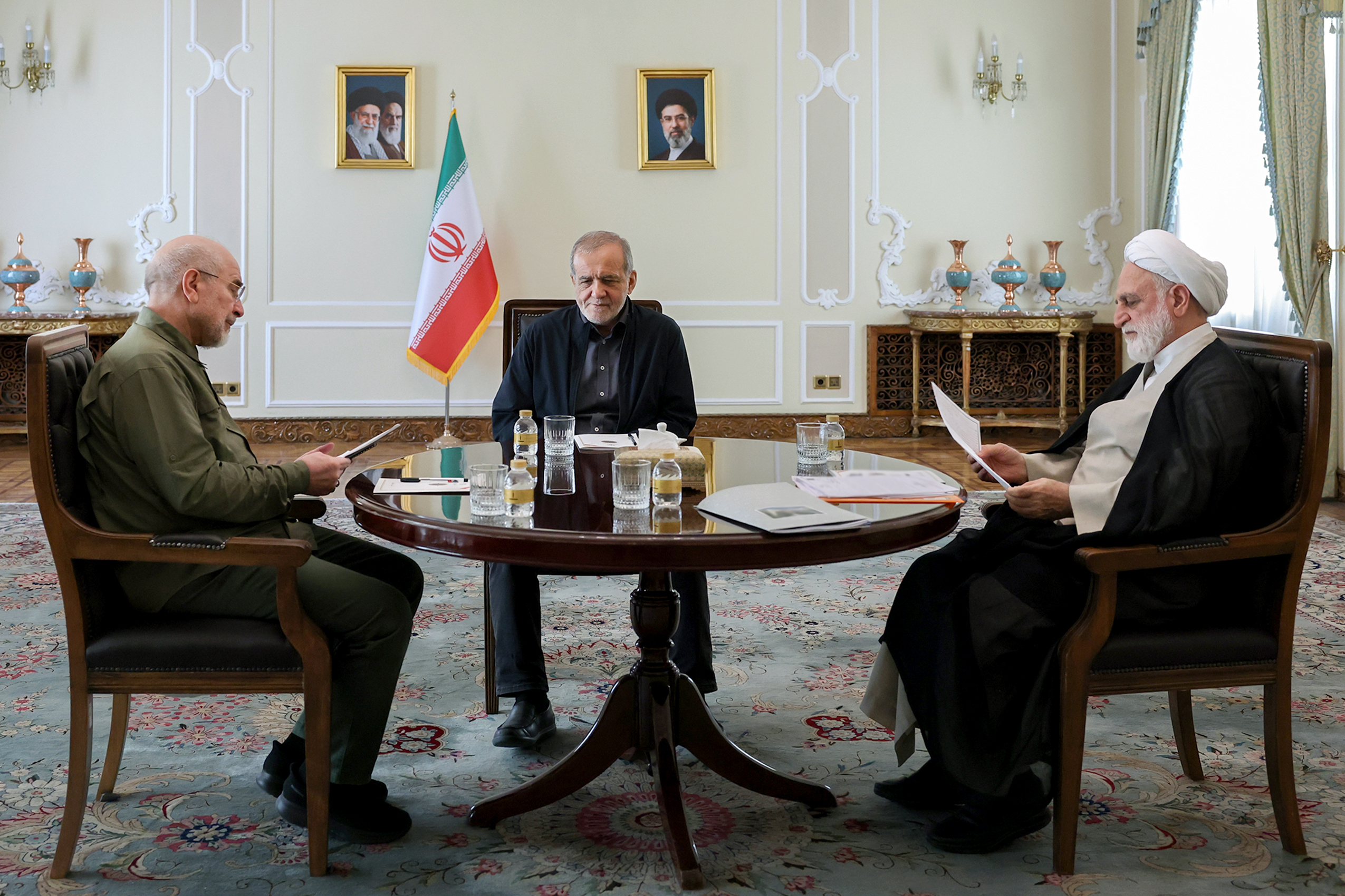 Iranian Parliamentary Speaker Mohammad-Bagher Qalibaf, left, President Masoud Pezeshkian, center, and Judiciary Chief Gholam-Hossein Mohseni Ejei sit around a table during a meeting at the presidential office in Tehran, Iran, October 4. (© Iranian Presidency via ZUMA Press)